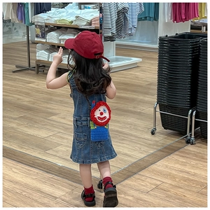 Handmade knitted clown shoulder bag for girls shown in a real-life lifestyle scene