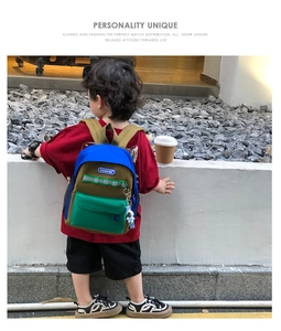 Close-up of kids color-block canvas backpack with reflective strips and astronaut charm