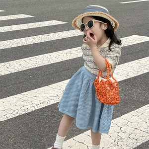 Girl in summer outfit with knitted polo shirt skirt and orange beaded handbag