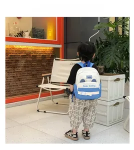Detail view of child's ergonomic blue and white backpack with Keep Smiling lettering