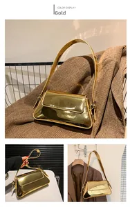 Details einer metallisch goldenen Baguette-Tasche mit verstellbarem Riemen und Glanz-Finish