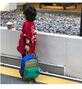 Detail of color-block kids backpack with reflective safety strip and side mesh pocket