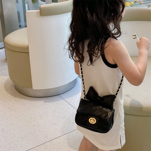 Girl's black quilted mini crossbody bag with chic bow detail and gold chain strap