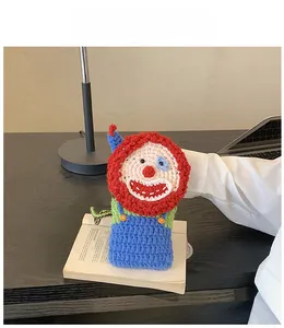 Detail of handmade crochet clown bag showing colorful knitted texture and funny face