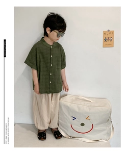 Détails de l'ensemble enfant avec chemise en lin vert foncé et pantalon beige ample