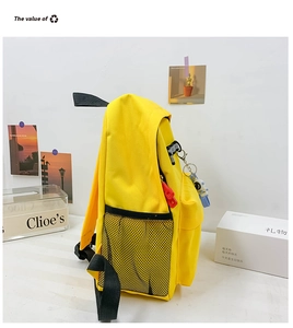 Close-up of yellow canvas backpack showing side mesh pocket and astronaut charm