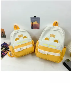 Two yellow and white patchwork backpacks with Keep Smiling embroidery and buckle straps