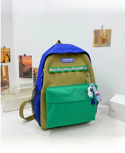 Detail of color-block canvas backpack with astronaut pendant and safety reflective strip