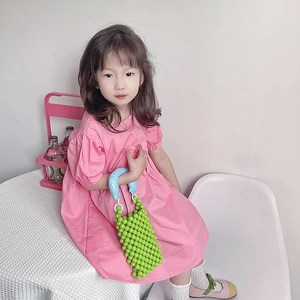 Borsa a mano verde con perline da bambina e manico blu imbottito mostrata da modella