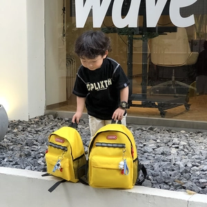 Vibrant yellow kids canvas backpack with safety reflectors and cute astronaut charm