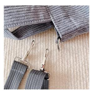 Detail of detachable shoulder strap with silver lobster clasp on grey corduroy bag