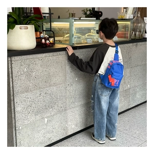 Detail der blauen Kinder-Brusttasche mit pinkem Fashion-Print und rotem Band-Zipper