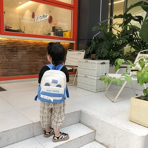 Blue and white kids ergonomic backpack for ages 3-6 with Keep Smiling print outdoors