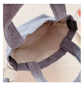 Internal detail of a blue corduroy child tote bag featuring inner lining and metal D-rings