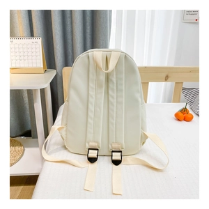 Rear view of cream white canvas backpack for kids featuring adjustable padded shoulder straps