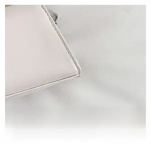 Macro shot of high-quality leather stitching and silver hardware on a crossbody bag