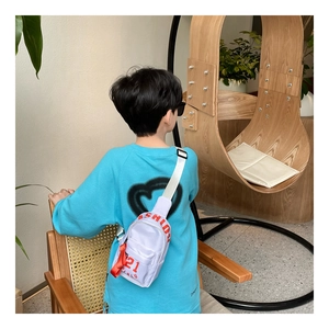 Detail der weißen Kinder-Hüfttasche aus Nylon mit rotem Fashion-Schriftzug und Gurt