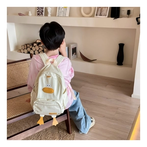 Detail of child wearing a cute cartoon duck backpack with yellow feet and soft straps