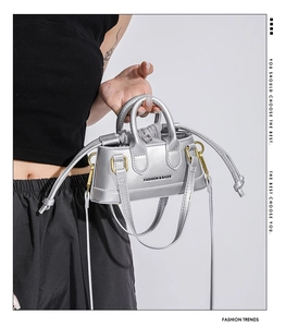 Detail of silver metallic mini bag featuring drawstring lining and fashion branding