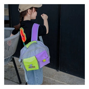 Detail of color-block kids backpack with multiple pockets and neon green accents