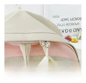 Detailed macro view of the smooth zipper on a pink and beige canvas kids backpack