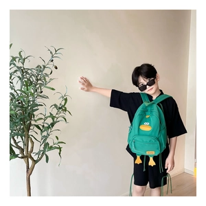 Detail view of the durable green canvas duck-shaped backpack with 3D bill and feet features