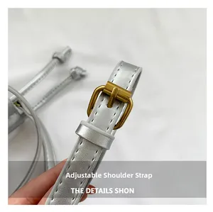 Detailed close-up of the adjustable silver strap with gold buckle and white stitching
