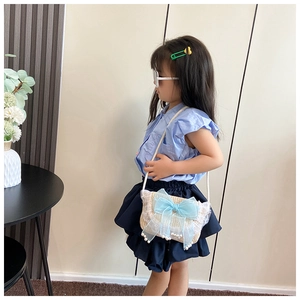 Stro geweven kindertas met lichtblauwe tule strik en elegante parelkwastjes decor
