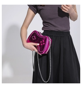 Detailaufnahme der metallisch-magentafarbenen Gamecontroller-Tasche mit Silberkette