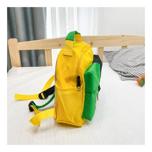 Side view of lightweight contrast color canvas backpack with mesh side pocket on a bed