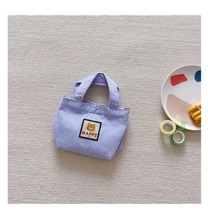 Detail of light purple corduroy texture with cute bear patch on a small handbag