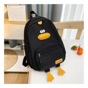 Detail of black cartoon duck backpack featuring cute yellow duck elements and brand tag