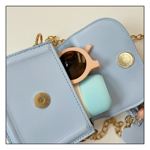 Close-up of light blue mini PU leather bag showing capacity for sunglasses and earbuds
