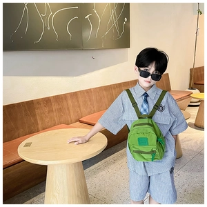 Détail d'un petit sac à dos enfant vert en nylon avec logo carré en silicone