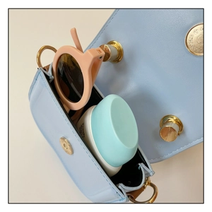 Detail of light blue mini leather bag showing interior space for sunglasses and cream