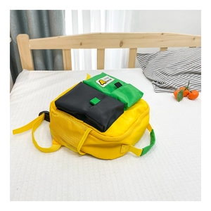 Detail of color-block kids backpack with yellow body, green pocket and bear brand label