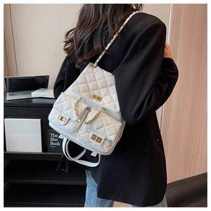 Detailed close-up of white quilted PU leather backpack with gold-tone hardware and chain straps