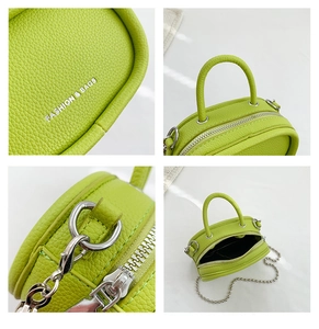 Macro view of green lychee leather texture and silver chain strap on mini bag