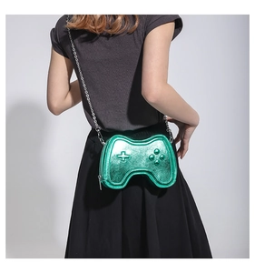 Detail der grünen Umhängetasche in Gamepad-Form mit silberner Kette für Damen