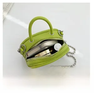 Top view of lime green mini chain bag showing internal storage for cosmetics and small items