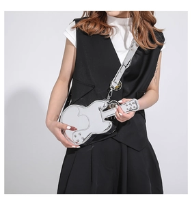 Detail showing metallic silver guitar-shaped crossbody bag with adjustable strap