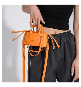 Detail of bright orange mini tote bag with dual handles and Fashion & Bags text logo