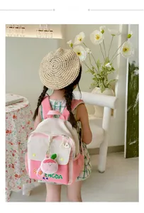 Pink and beige color-block kids backpack with cute rabbit charm on girl model back