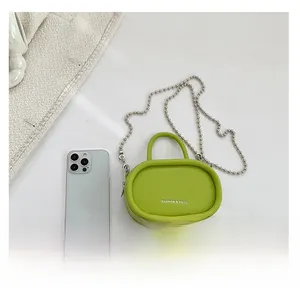 Mini lime green leather bag with silver chain next to a smartphone for size reference