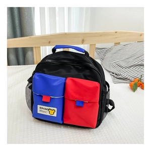 Detail of color-block kid backpack featuring blue and red pockets and side mesh pocket