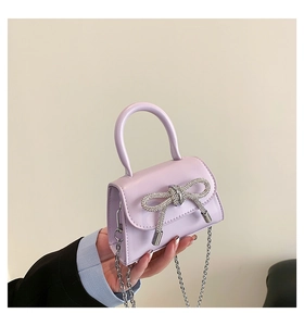 Detailed view of lavender mini bag featuring rhinestone bow and silver chain strap