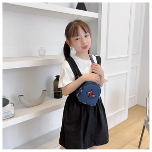 Détail du sac de poitrine bleu pour enfants avec broderie dinosaure et fermeture éclair