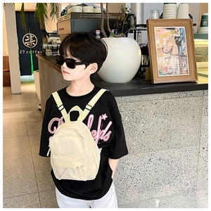 Détail du mini sac à dos crème pour enfants avec logo Girl Cats en relief sur la poche