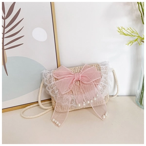 Detail van beige strooien kindertas met roze mesh strik, parels en witte kantrand