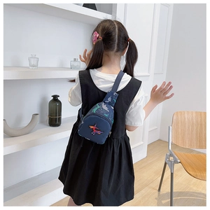 Détail du sac de poitrine bleu pour enfant avec motif dinosaure et bandoulière